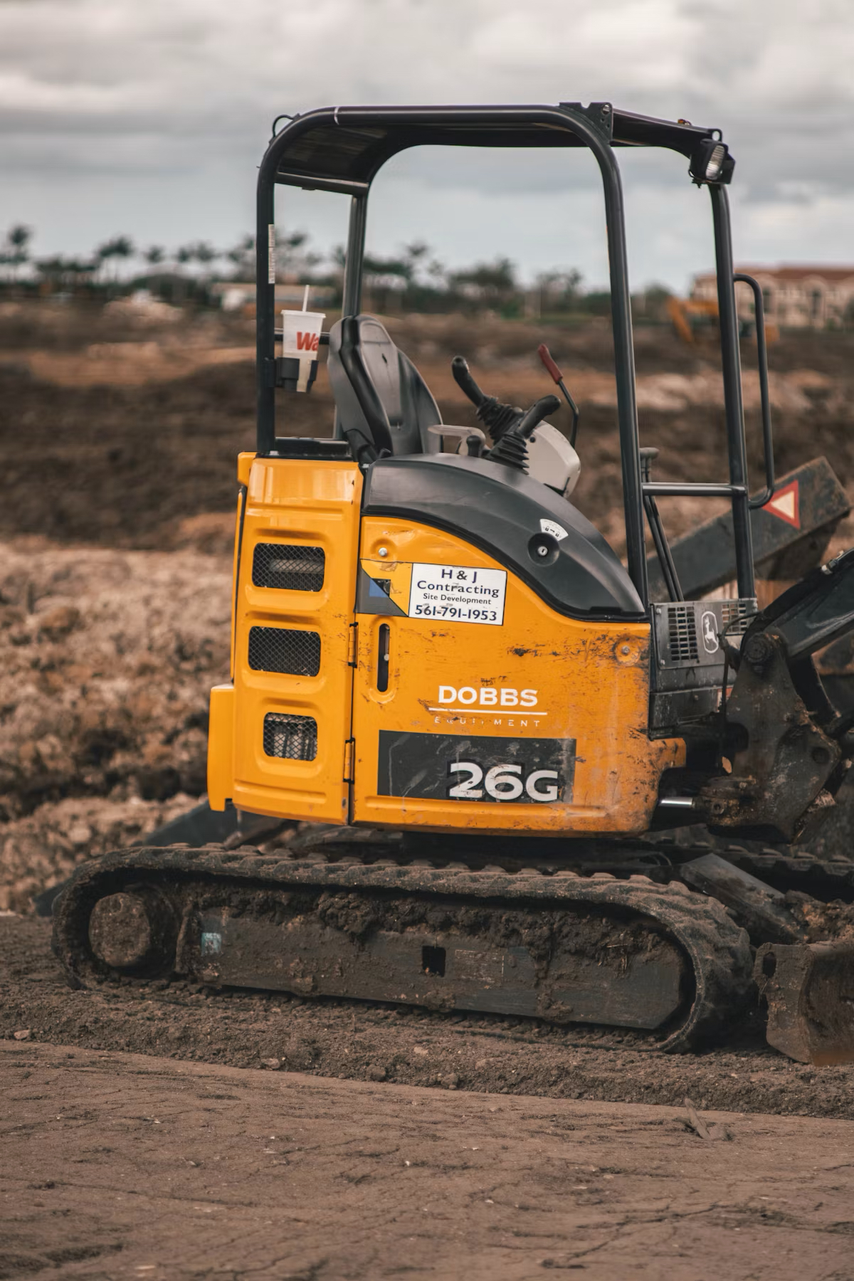 Compact tracked excavator working on a development site